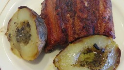 Recepta de cuina de Costella ibèrica de porc a la planxa amb patata al caliu i mantega aromatitzada a l'all negre