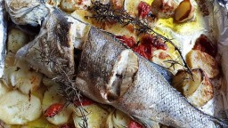 Recepta de cuina de Llobarro al forn amb patates, ceba i tomàquet