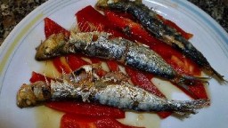 Arengades o sardines de costa sobre  llit de pebrot vermell