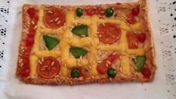 Recepta de cuina de Coca amb pasta de full, crema, fruites confitades i pinyons