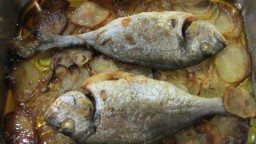 Recepta de cuina de Orada fresca al forn amb base de ceba i patates a rodanxes