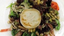 Recepta de cuina de Amanida de favetes confitades, anxoves, tomàquet, fulls verds i formatge de cabra