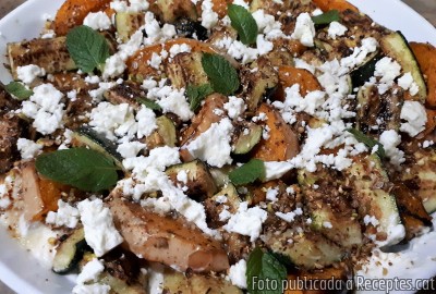 Escampar la resta del formatge feta esmicolat, seguit dels festucs, les llavors de coriandre i les escates de Xile. Cobrir amb les fulles de menta i servir. Recepta de cuina de Amanida de carbassa i carbassons rostits amb formatge feta batut i festucs