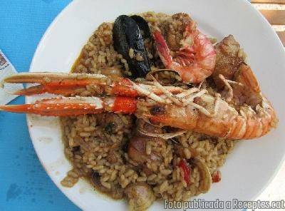 Paella de carn i marisc feta al camp amb llenya de ceps de vinya