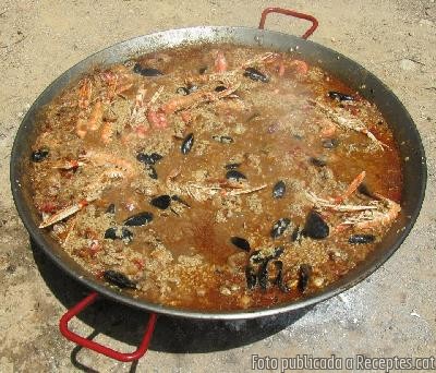 Paella de carn i marisc feta al camp amb llenya de ceps de vinya