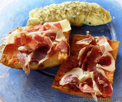Truita d'ous ecològics de Ca La Xica amb bolets de primavera i crema àcida de cabra acompanyada de pa de coca amb tomàquet i pernil ibèric. Recepta de cuina de Truita d'ous ecològics amb bolets de primavera i crema àcida de cabra acompanyada de pa de coca amb tomàquet i pernil ibèric